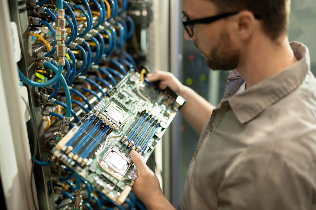 IT support specialist examining motherboard of server