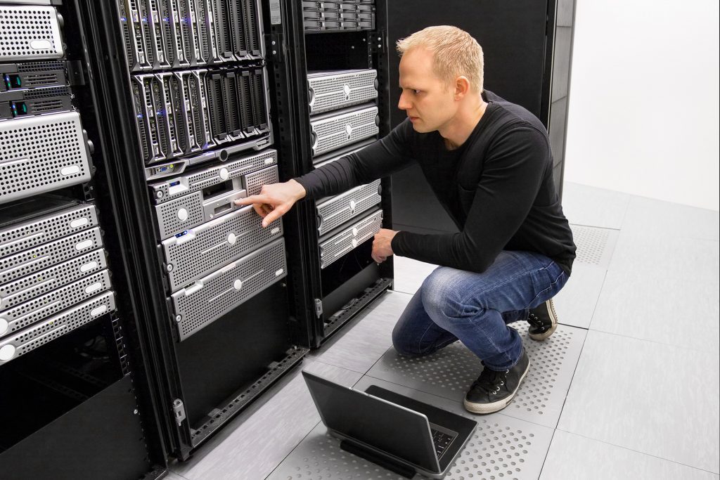 IT consultant working with laptop in datacenter